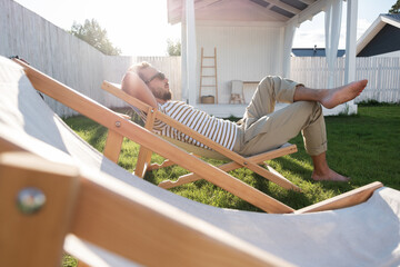 Barefoot man chilling in backyard