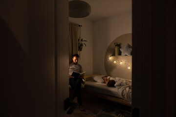 Father reading book to sleeping child