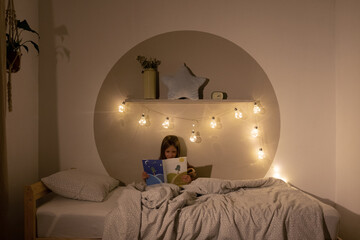 Girl reading book at night