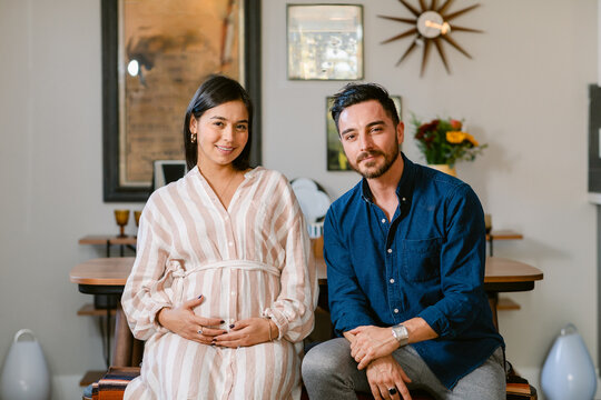 Expectant couple sitting at home portrait