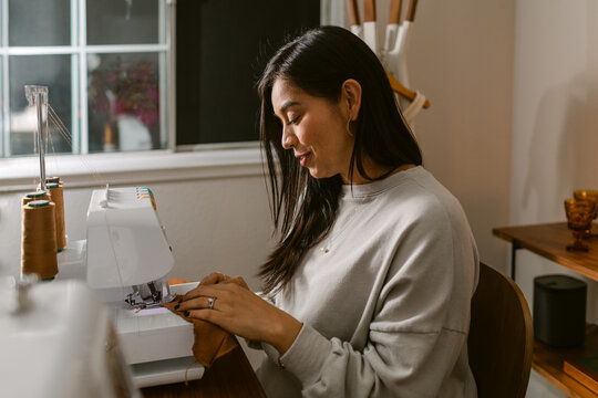 Woman sewing on machine at home