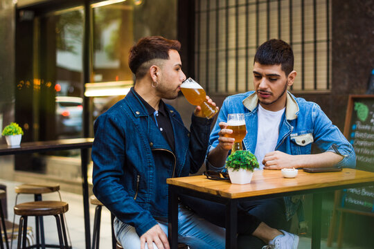 Latino gay couple drinking beer