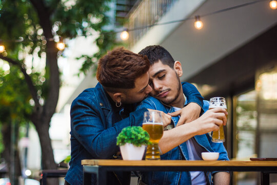 Gay latino couple intimate moment while having a beer