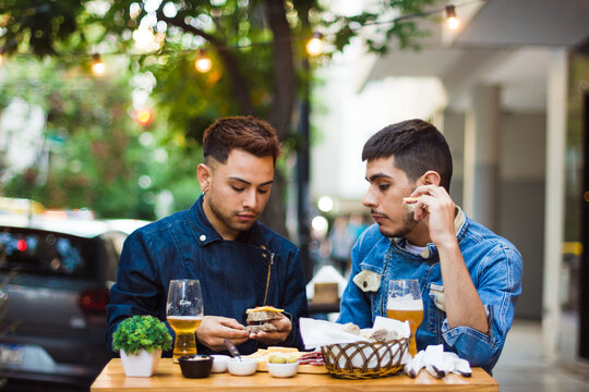 Gay latino couple dining at restaurant outdoors
