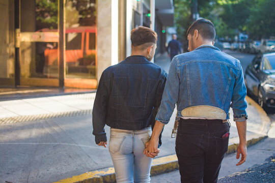 Latino gay couple walking holding hands