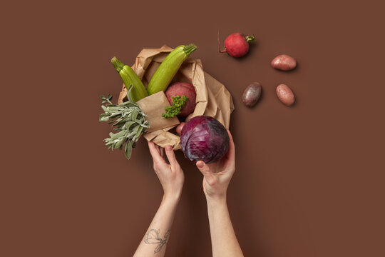 Female hands packing vegetables inside box