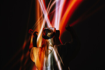 Anonymous woman in VR Headset standing on glowing background