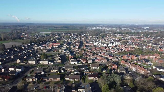 Aerial view village Sprundel in Netherlands with soccerfields SV Sprundel clear blue sky and Etten-Leur at the horizon