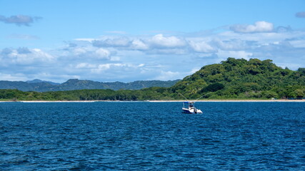 Fototapeta na wymiar Boat moored in the bay in front of Tamarindo, Guanacaste, Costa Rica