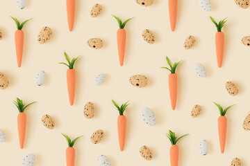 Easter pattern made with carrots and easter eggs on bright pastel yellow background.Creative  minimal Easter holiday concept spring holiday celebration greeting card or idea. Flat lay.