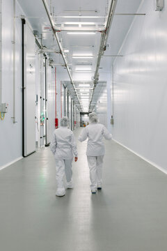 Unrecognizable people walking in industrial corridor