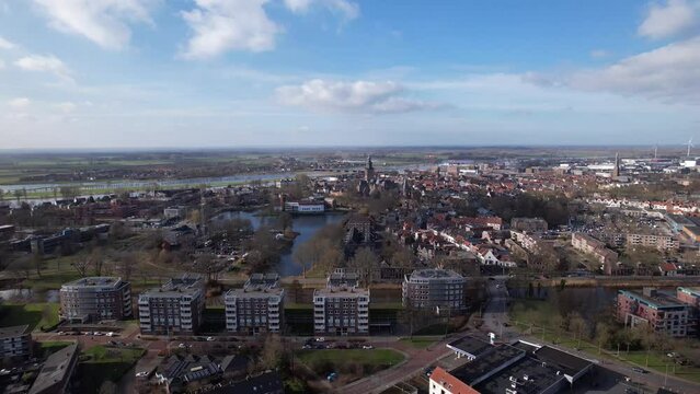Backwards aerial movement showing residential neighbourhoods of Zutphen revealing former youth prison facility, now abandoned waiting for demolition and refurbishment of the moated plot field