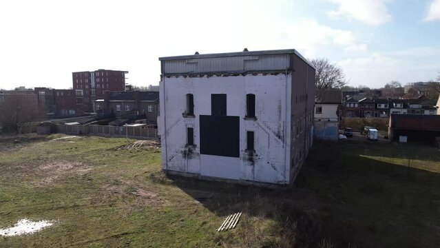 Closeup aerial pan around former youth prison facility, now abandoned waiting for demolition and refurbishment of the moated plot field in a residential neighbourhood of Zutphen, The Netherlands