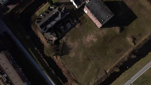 Top down aerial approach of former youth prison facility, now abandoned waiting for demolition and refurbishment of the moated plot field in a residential neighbourhood of Zutphen, The Netherlands