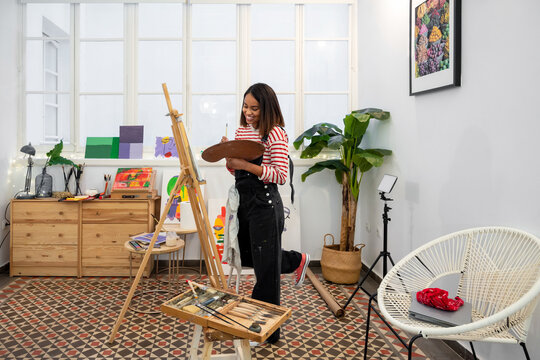 Woman painting on easel in workshop