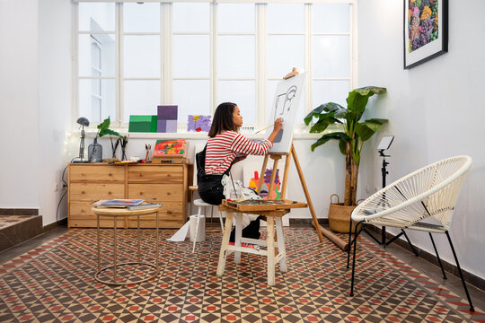 Woman painting on easel in workshop