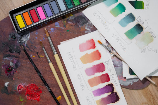 Painting supplies on wooden table in art studio