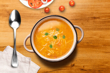 Una deliciosa sopa caliente sobre una tabla de madera y unos tomates cherry 