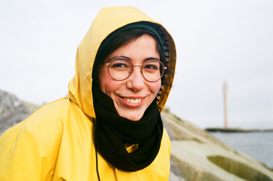 Portrait of a positive smiley woman wearing a yellow raincoat