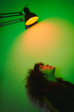 woman on a chair under a colored lamp