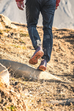 Trail runner walking over rocky terrain.