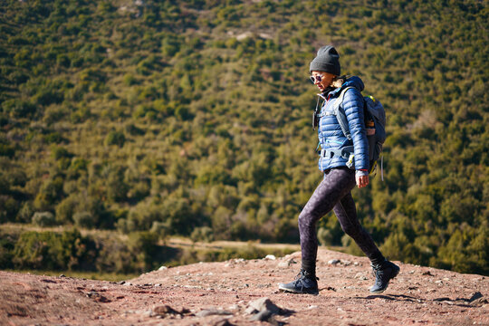 Young female hiker walking in highlands on sunny day