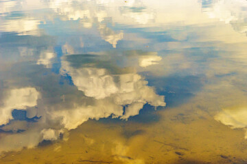 Reflection in the water of the sky and the bottom of the river