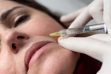 Crop woman receiving anti aging injection in salon