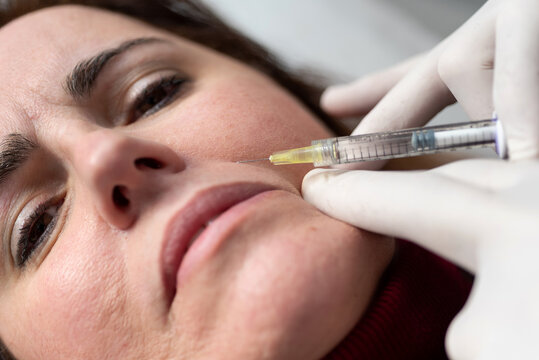 Crop woman receiving anti aging injection in salon