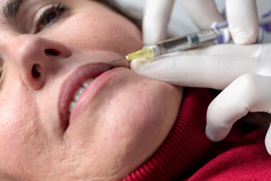 Crop woman receiving anti aging injection in salon