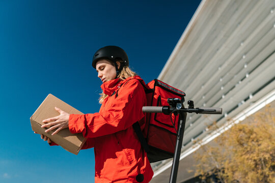 Young woman checking box during delivery service