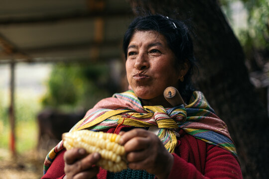 Latin woman eating an ear of corn
