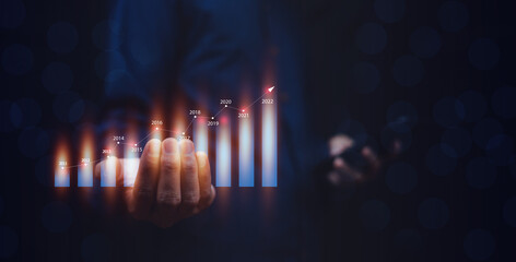 Businessman trader or investor holding digital graph on technology visual screen for trading online stock market forex or stock exchange