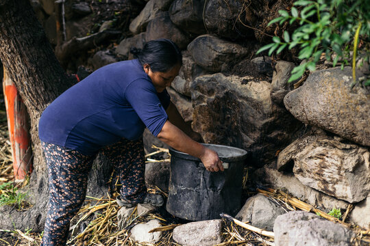 Latin woman cooking on a campfire