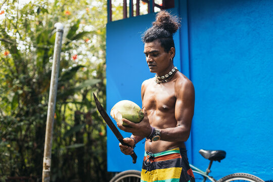 Native american man cutting a coconut