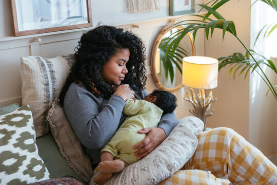 Caring black mother breastfeeding baby