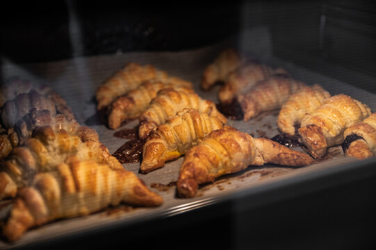 Tasty croissants baking in hot oven
