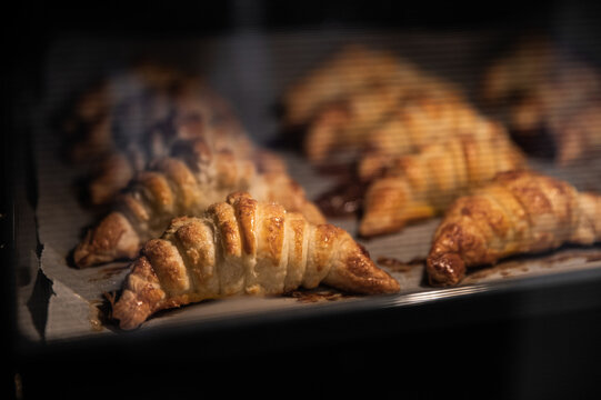 Tasty croissants baking in hot oven