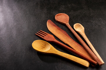 Wooden cutlery on dark background.