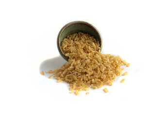 Instant Brown Rice Spills from Green Pottery Bowl Isolated on White