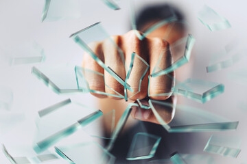 close up of a man's fist punching and breaking glass to pieces - Home security Concept - business...