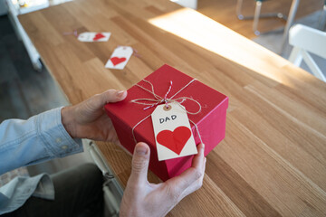 Man holding gift for his father in kitchen