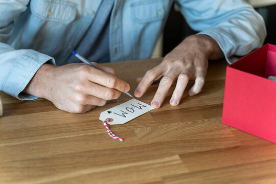 Man writing mom on gift card