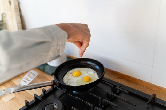 Man cooking eggs in pan 