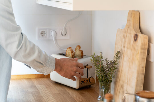 Close-up of man making toasts on toaster