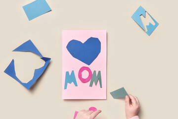 Kid making postcard from colorful paper