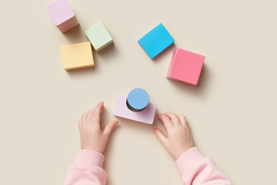 Baby playing with wooden toys of geometric figures