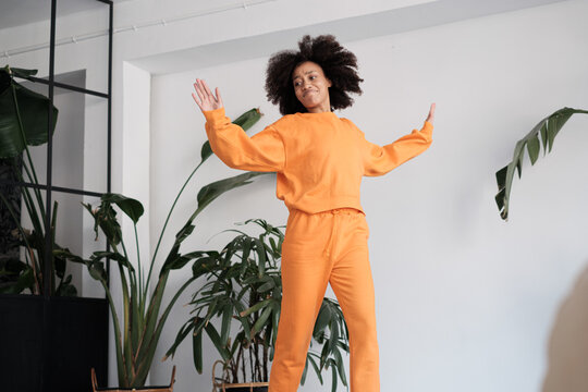 Afro woman dancing indoors