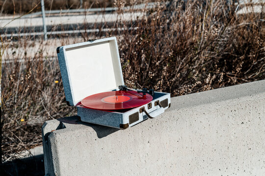portable turntable with a red disc outdoors