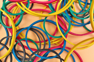 Full Frame Image Flatlay of Multicolored Elastic Rubber Bands on a Cheerful Orange Pastel Background